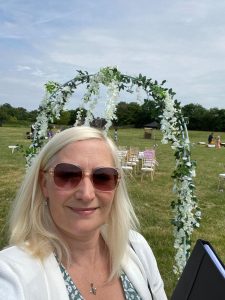 Joanne Jefferis Wedding Celebrant at outdoor venue with floral arch